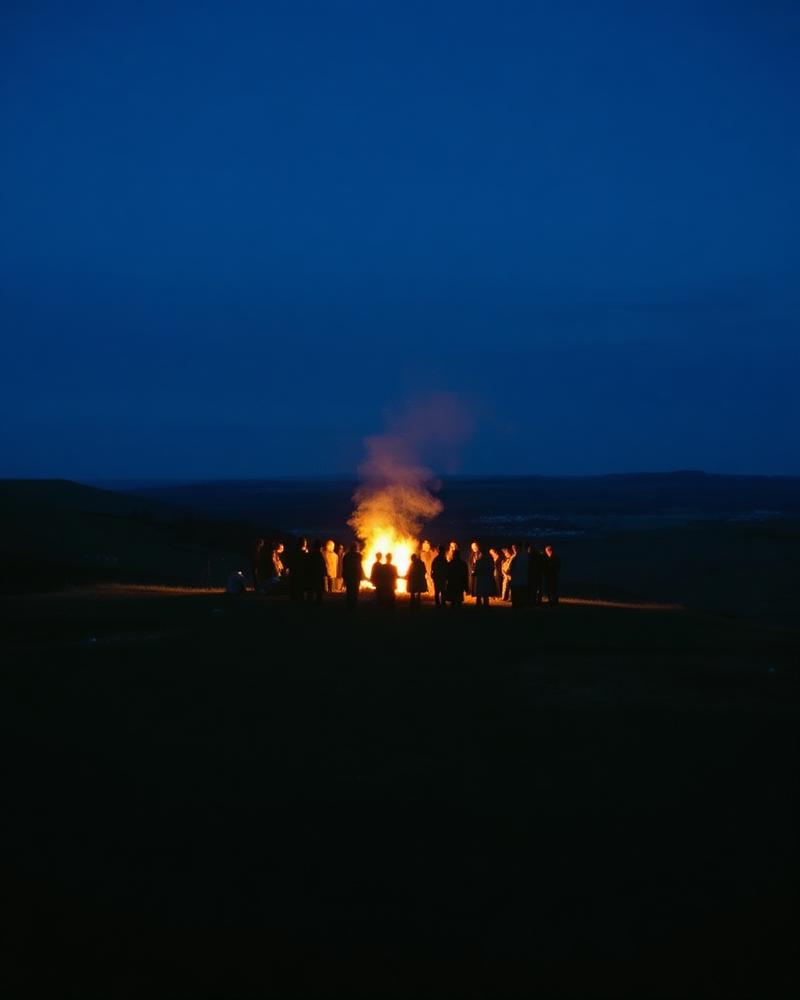Silhouettes around a bonfire on an Irish hillside at dusk